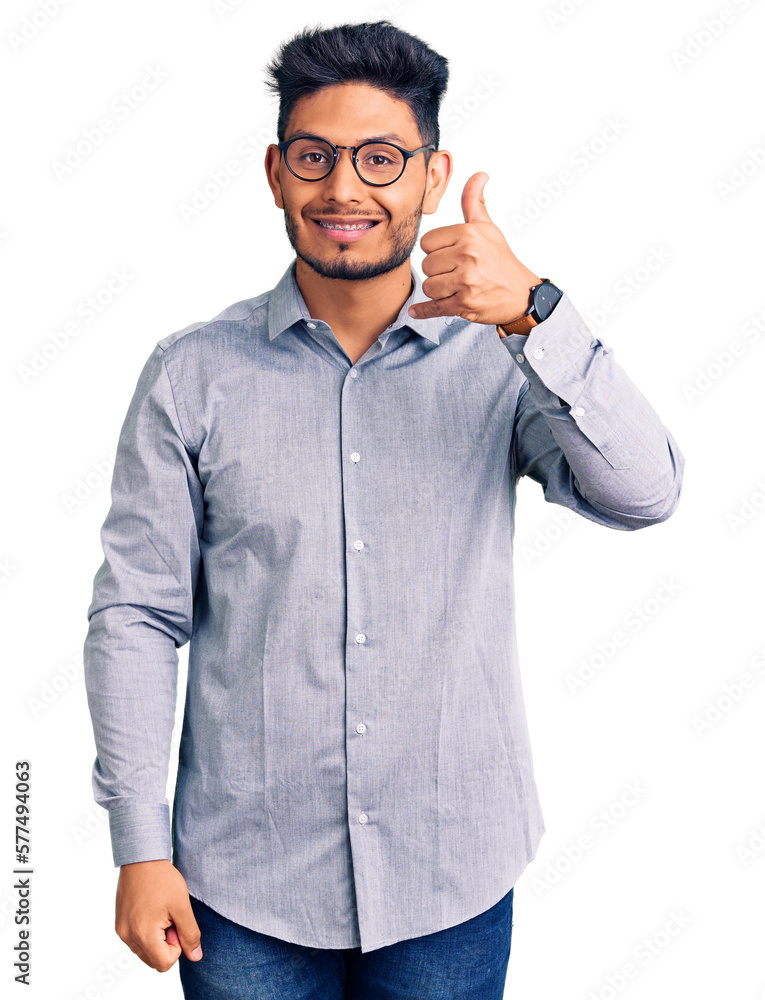 Handsome latin american young man wearing business clothes and glasses smiling happy and positive, thumb up doing excellent and approval sign Handsome latin american young man wearing business clothes and glasses smiling happy and positive, thumb up doing excellent and approval sign