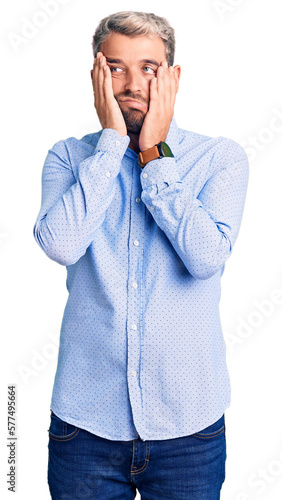 Young handsome blond man wearing elegant shirt tired hands covering face, depression and sadness, upset and irritated for problem © Krakenimages.com
