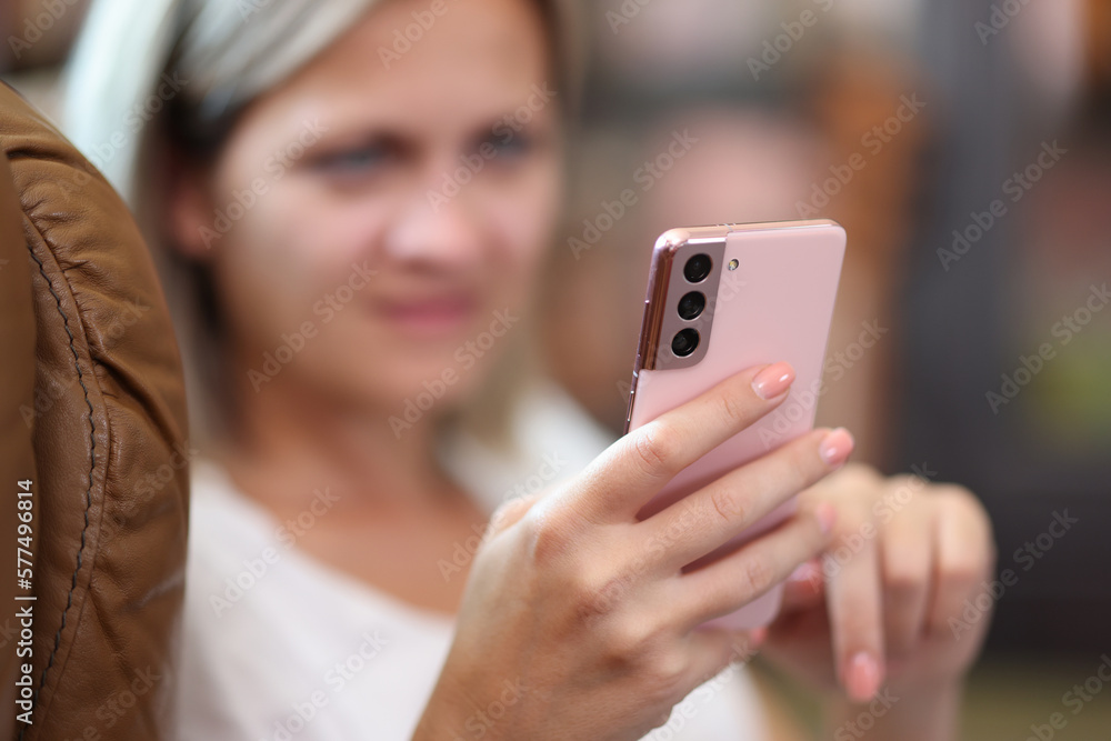 Young woman holding modern smartphone in hands Young woman holding modern smartphone in hands