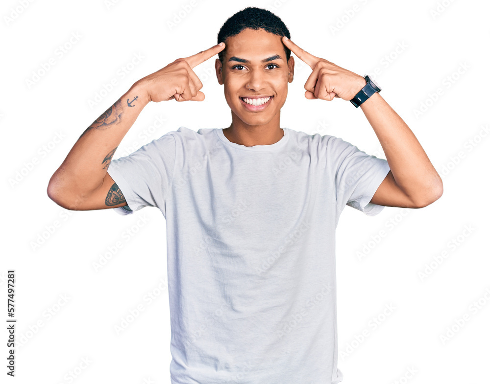Young hispanic man wearing casual white t shirt smiling pointing to head with both hands finger, great idea or thought, good memory Young hispanic man wearing casual white t shirt smiling pointing to head with both hands finger, great idea or thought, good memory