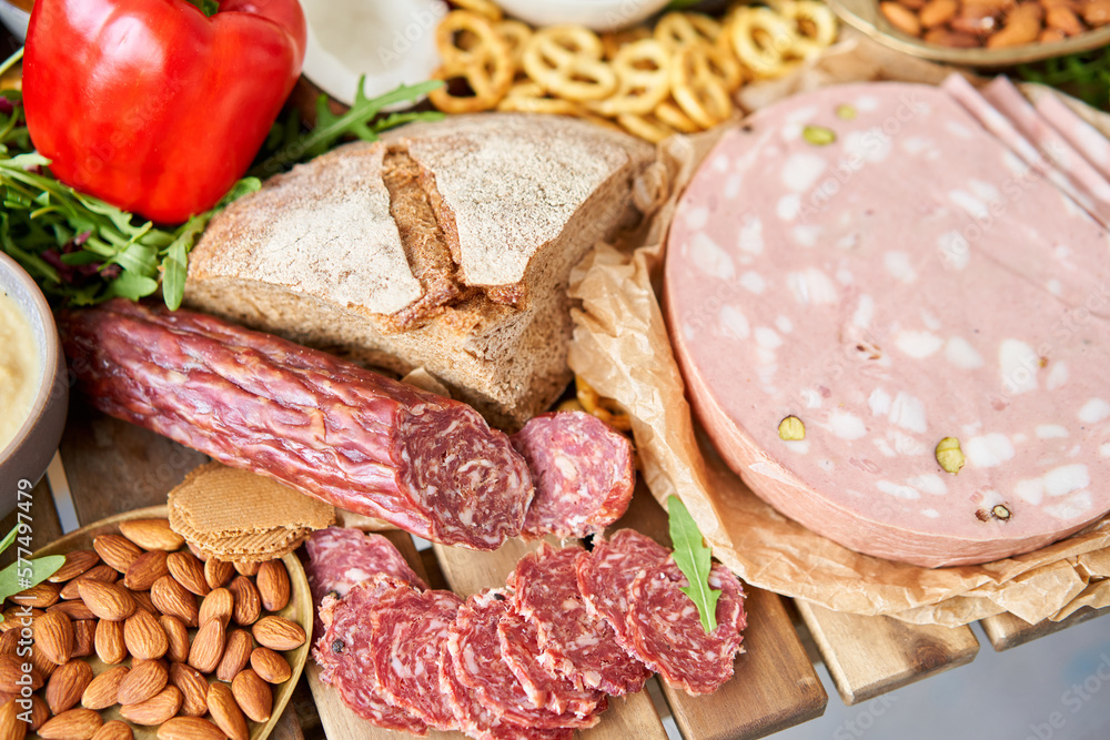 Parma sausage close-up. Table full of mediterranean appetizers, tapas or antipasto. Assorted Italian food set. Delicious snack on party or picnic time. Meat and cheese. Italian style banquet. Parma sausage close-up. Table full of mediterranean appetizers, tapas or antipasto. Assorted Italian food set. Delicious snack on party or picnic time. Meat and cheese. Italian style banquet.