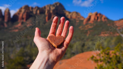 Hand holding heart shaped rock in Sedona, Arizona photo