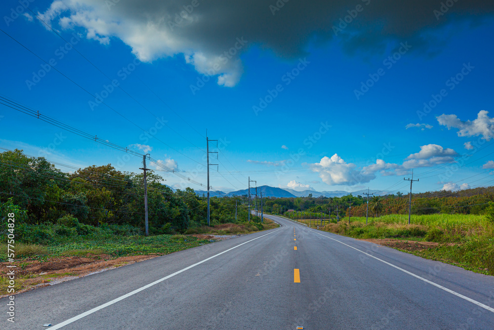 beautiful road and mountain scenery in thailand,Asphalt road through the green field and clouds on blue sky in summer day. Beautiful grassland road in Thailand.Highland road.