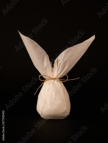 White paper wrap in shape of bunny on black background 
