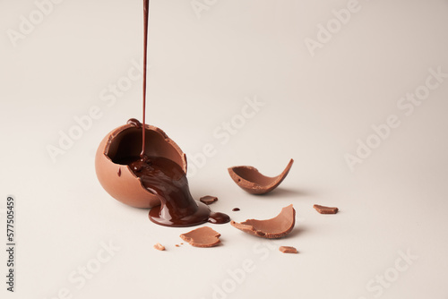 Valokuva Crushed Brown Chocolate egg with liquid chocolate pour on white background