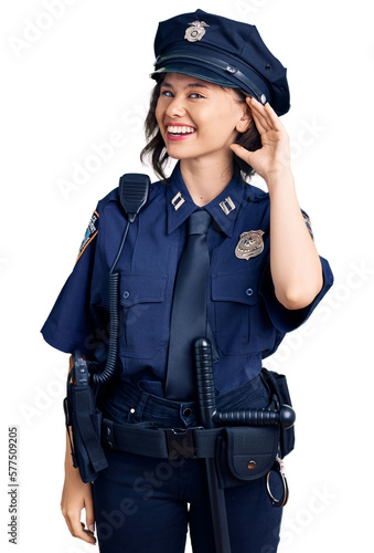 Young beautiful girl wearing police uniform smiling with hand over ear listening an hearing to rumor or gossip. deafness concept.
