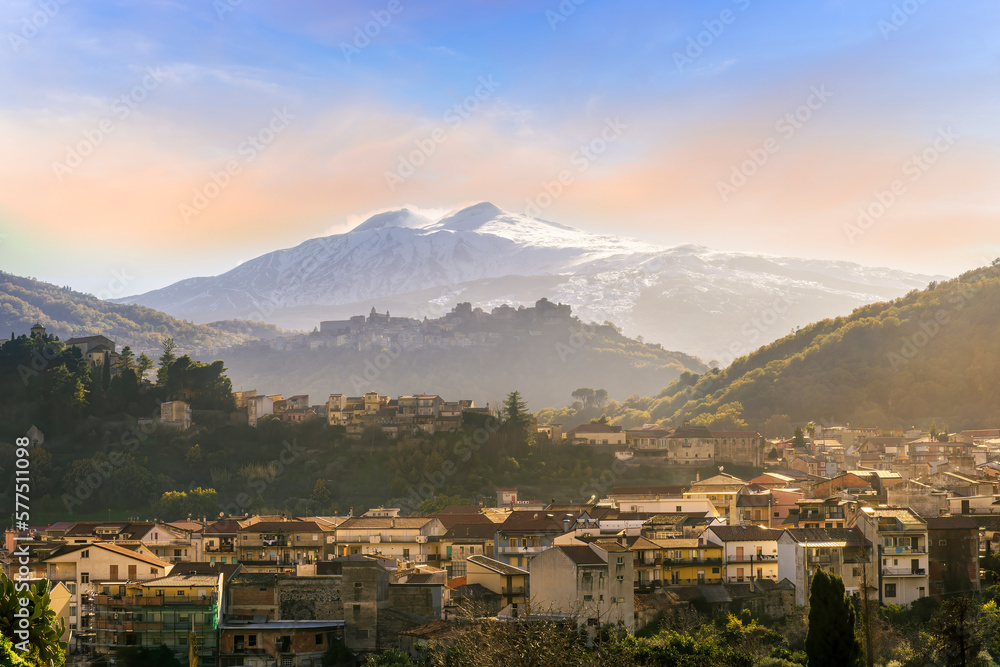 Fototapeta premium highland travel landscape, scenic view to a beautiful mountain town in sunrise or sunset with snow on top of mountains on background and amazing colorful sky
