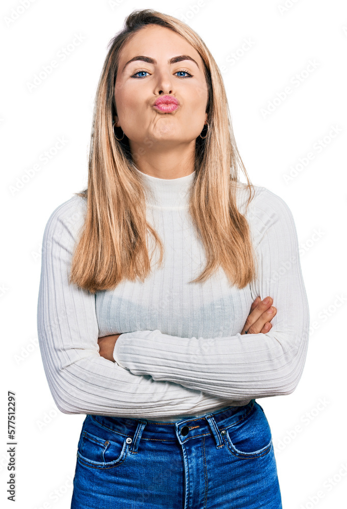 Young blonde woman with arms crossed gesture looking at the camera blowing a kiss being lovely and sexy. love expression. Young blonde woman with arms crossed gesture looking at the camera blowing a kiss being lovely and sexy. love expression.