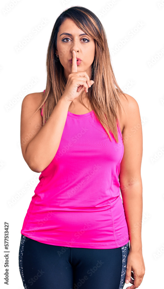 Young beautiful woman wearing sportswear asking to be quiet with finger on lips. silence and secret concept. Young beautiful woman wearing sportswear asking to be quiet with finger on lips. silence and secret concept.