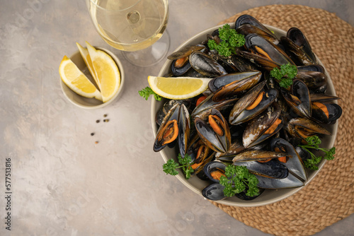 Delicious seafood mussels with with sauce and parsley. Lemon slices. Clams in the shells. © Mihai