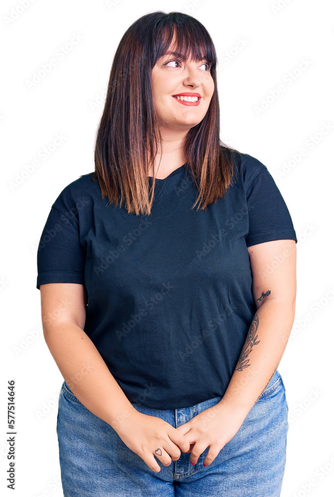 Young plus size woman wearing casual clothes looking away to side with smile on face, natural expression. laughing confident. Young plus size woman wearing casual clothes looking away to side with smile on face, natural expression. laughing confident.