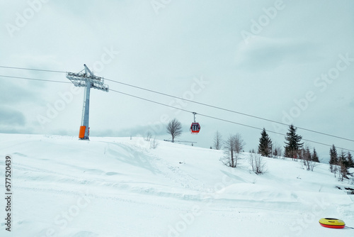 ski resort Goderdzi, Georgia. mountains are covered with snow. Red cable car above and mountains behind - Image
