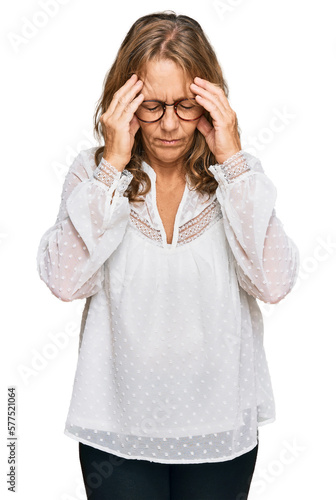 Middle age blonde woman wearing casual white shirt and glasses with hand on head for pain in head because stress. suffering migraine.