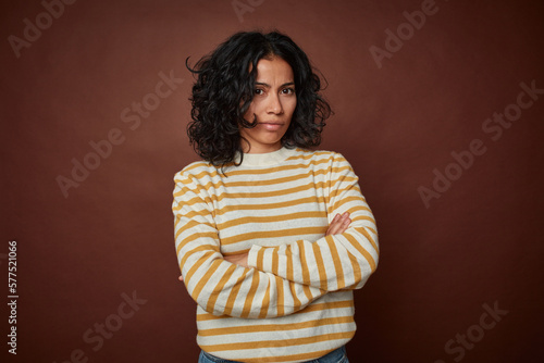 Foto Young colombian curly hair woman isolated on brown background suspicious, uncertain, examining you
