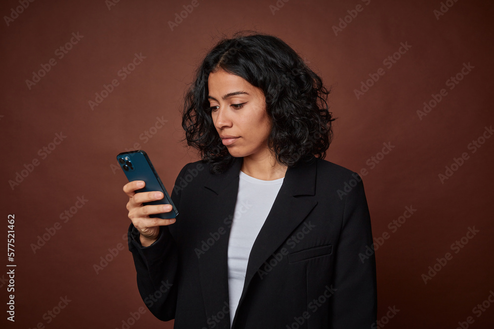 Young businesswoman using her mobile phone for work, multitasking efficiently. Young businesswoman using her mobile phone for work, multitasking efficiently.