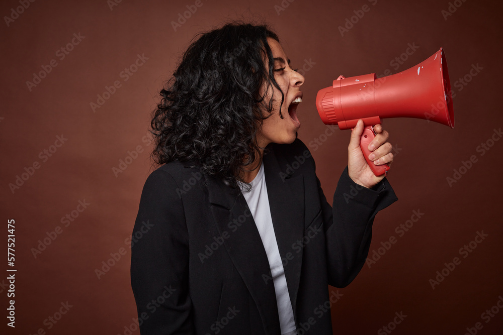 A young business woman passionately advocates for her rights with a megaphone. A young business woman passionately advocates for her rights with a megaphone.