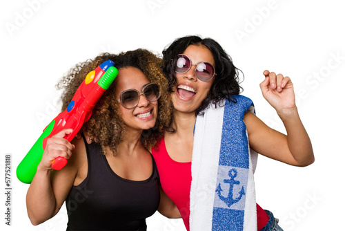 Two women, one with Afro hair and the other Latina, are ready for a beach vacation in their swimwear. 