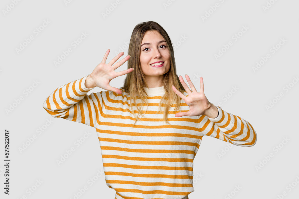Young blonde posing for a portrait isolated, exuding natural beauty and radiance showing number ten with hands. Young blonde posing for a portrait isolated, exuding natural beauty and radiance showing number ten with hands.
