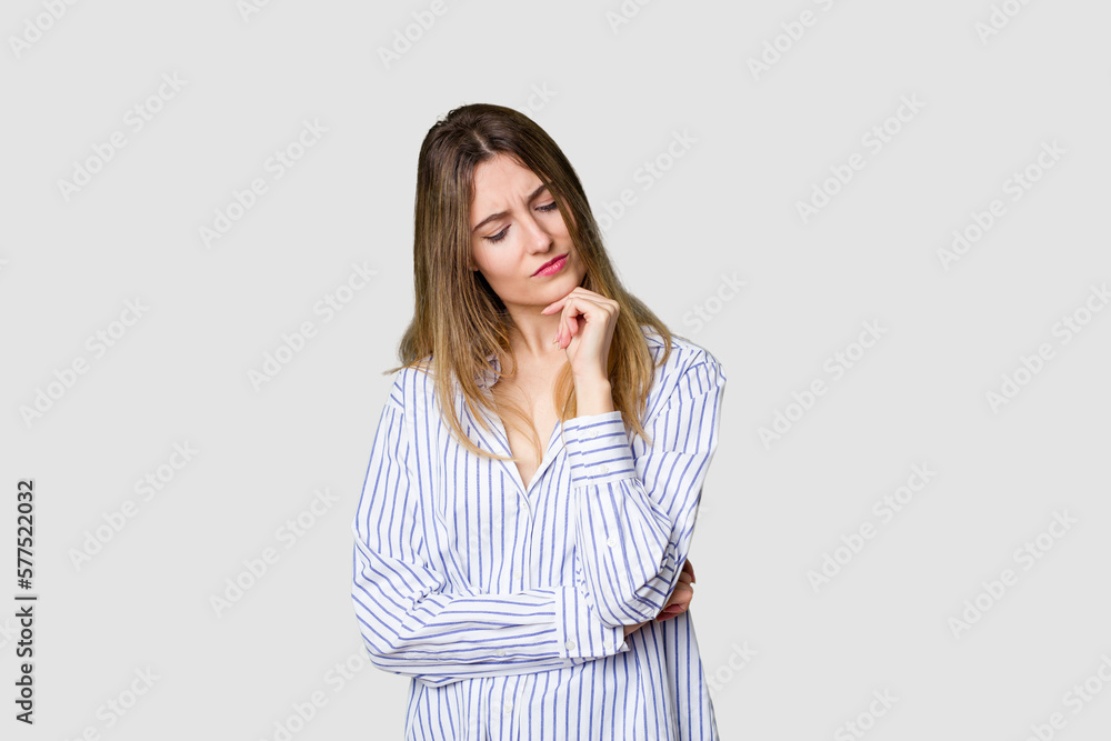 Young blonde posing for a portrait isolated, exuding natural beauty and radiance looking sideways with doubtful and skeptical expression. Young blonde posing for a portrait isolated, exuding natural beauty and radiance looking sideways with doubtful and skeptical expression.