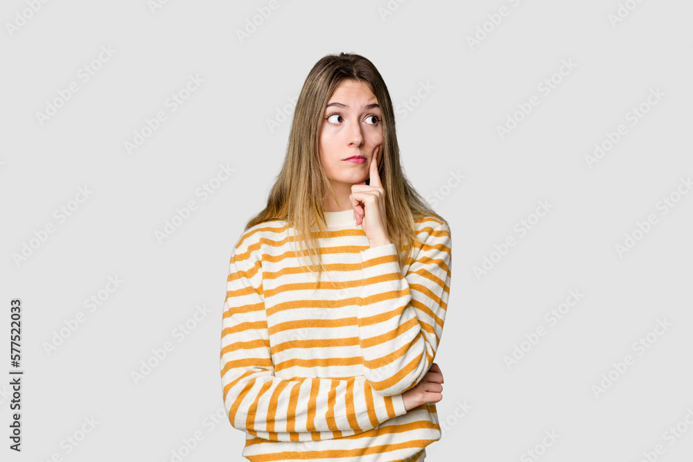 Young blonde posing for a portrait isolated, exuding natural beauty and radiance contemplating, planning a strategy, thinking about the way of a business. Young blonde posing for a portrait isolated, exuding natural beauty and radiance contemplating, planning a strategy, thinking about the way of a business.