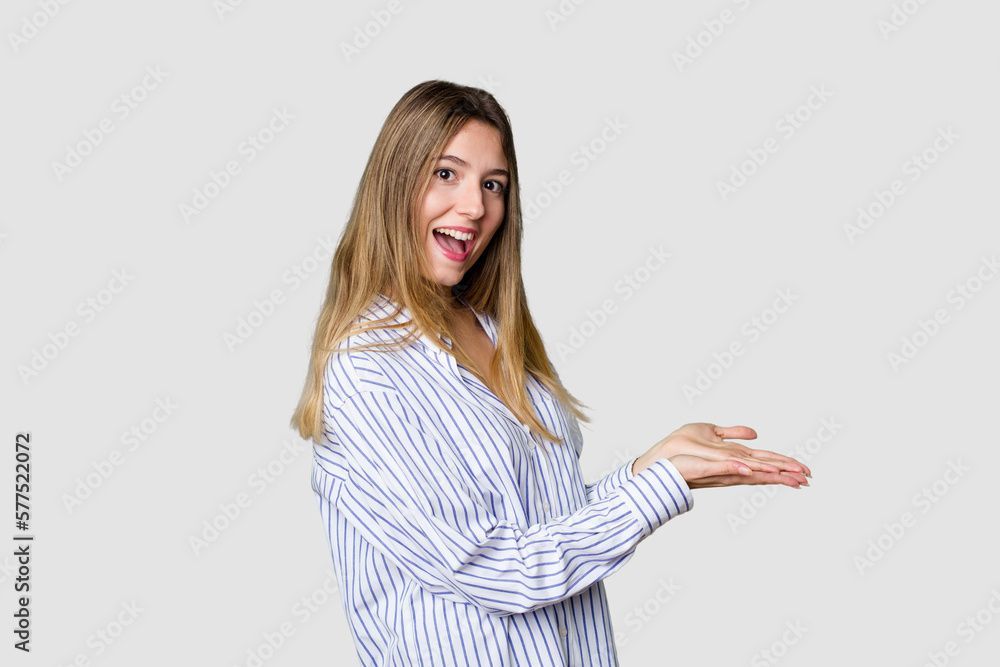 Young blonde posing for a portrait isolated, exuding natural beauty and radiance holding a copy space on a palm. Young blonde posing for a portrait isolated, exuding natural beauty and radiance holding a copy space on a palm.