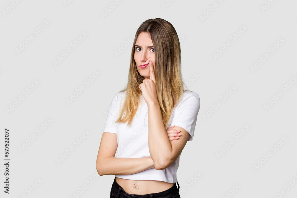 Fototapeta premium Young blonde posing for a portrait isolated, exuding natural beauty and radiance unhappy looking in camera with sarcastic expression.