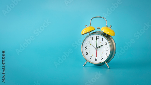 Retro silver alarm clock.  2:00, am, pm. Blue background.
