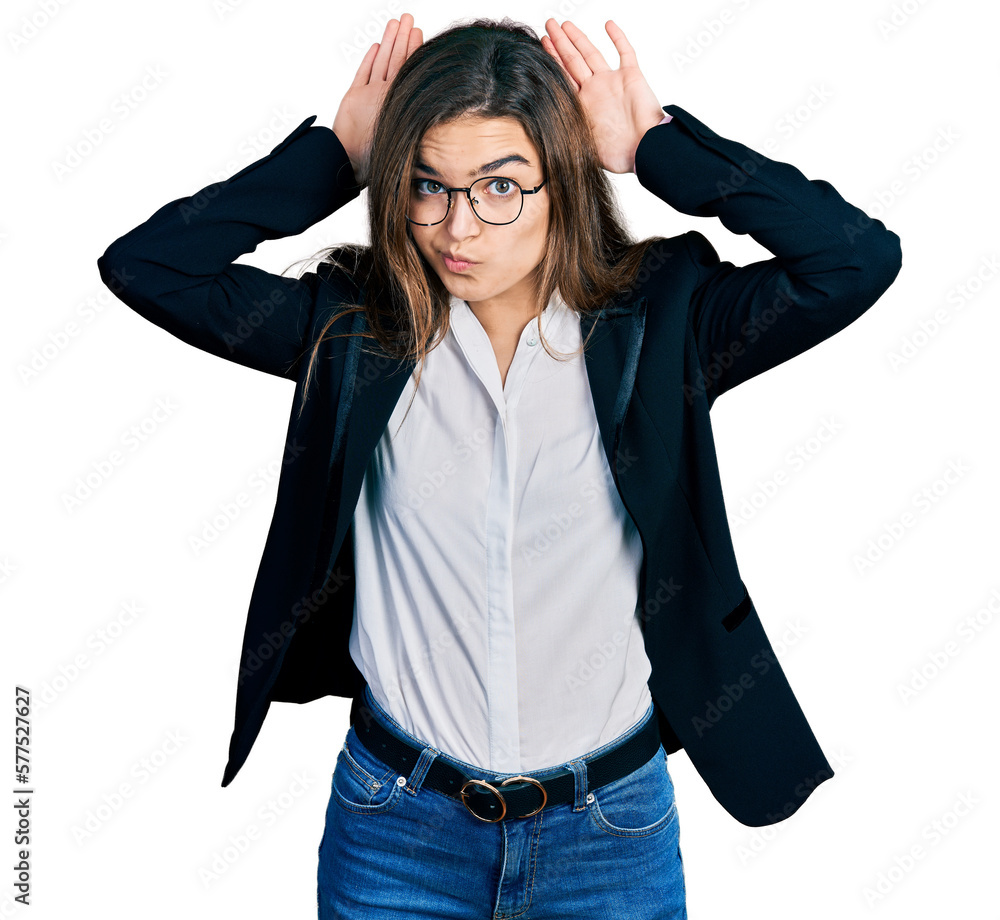 Young caucasian girl wearing business style and glasses doing bunny ears gesture with hands palms looking cynical and skeptical. easter rabbit concept. Young caucasian girl wearing business style and glasses doing bunny ears gesture with hands palms looking cynical and skeptical. easter rabbit concept.