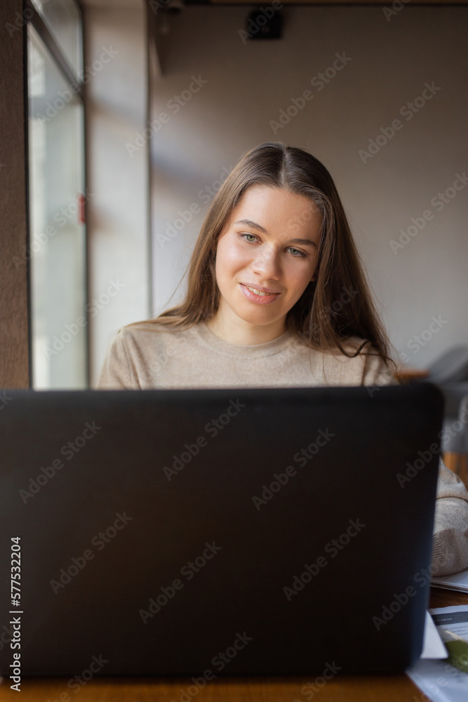 Young women working with laptop while sitting at café Young women working with laptop while sitting at café