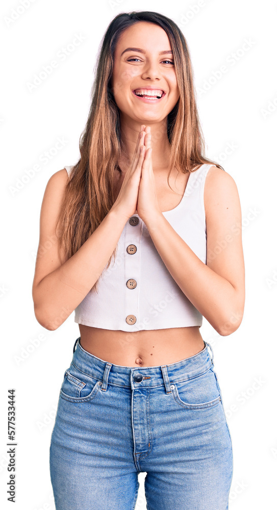 Young beautiful girl wearing casual sleeveless t shirt praying with hands together asking for forgiveness smiling confident. Young beautiful girl wearing casual sleeveless t shirt praying with hands together asking for forgiveness smiling confident.