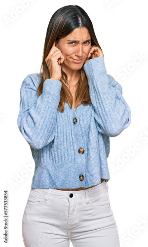 Young woman wearing casual clothes covering ears with fingers with annoyed expression for the noise of loud music. deaf concept.