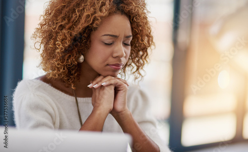 Business on the mind. Shot of a young businesswoman with her eyes closed sitting in her office.