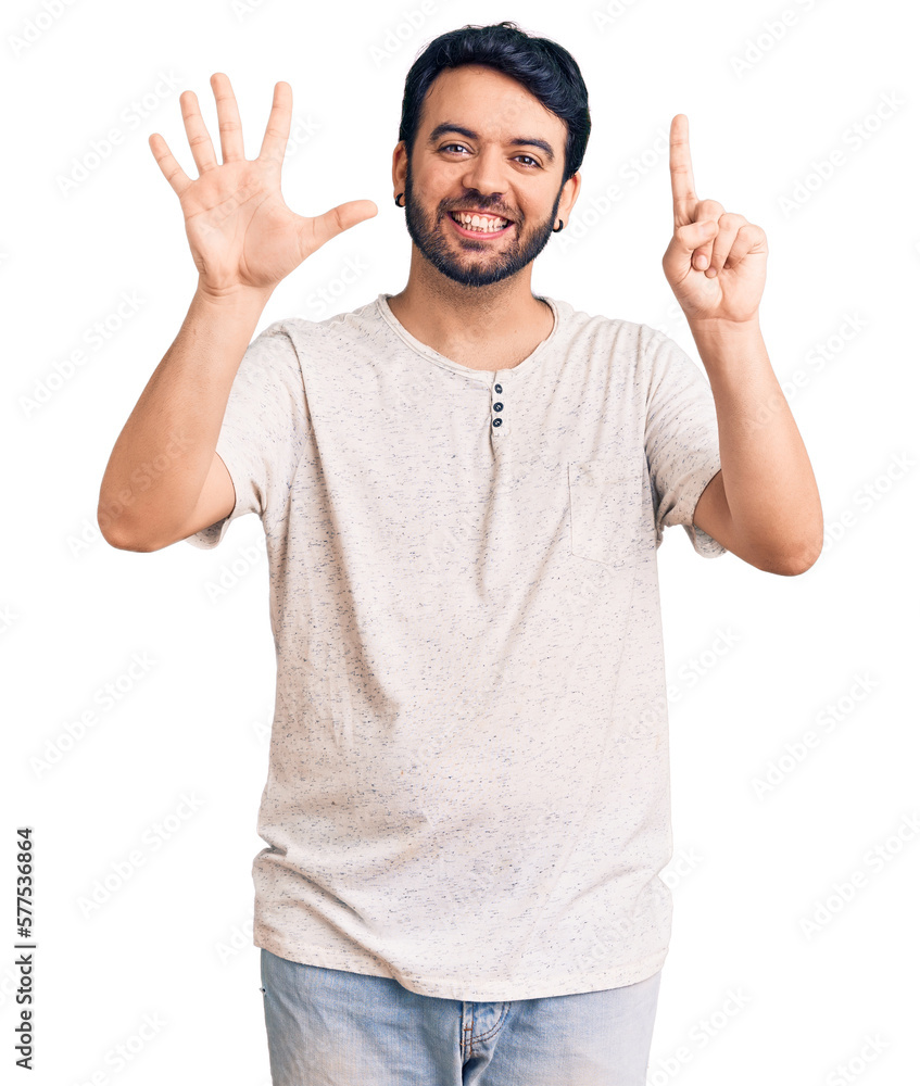 Naklejka premium Young hispanic man wearing casual clothes showing and pointing up with fingers number six while smiling confident and happy.
