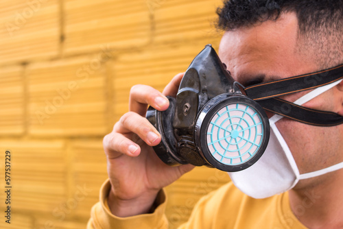 Man taking off the gas mask on yellow background