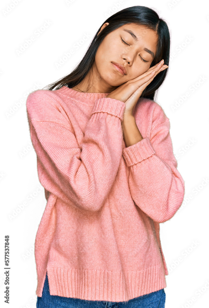 Beautiful young asian woman wearing casual winter sweater sleeping tired dreaming and posing with hands together while smiling with closed eyes. Beautiful young asian woman wearing casual winter sweater sleeping tired dreaming and posing with hands together while smiling with closed eyes.