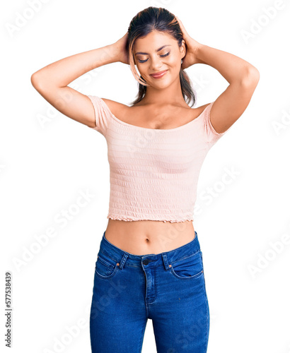 Young beautiful woman wearing casual clothes relaxing and stretching  arms and hands behind head and neck smiling happy