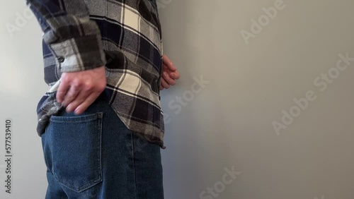man hand putting wallet in jeans pocket
