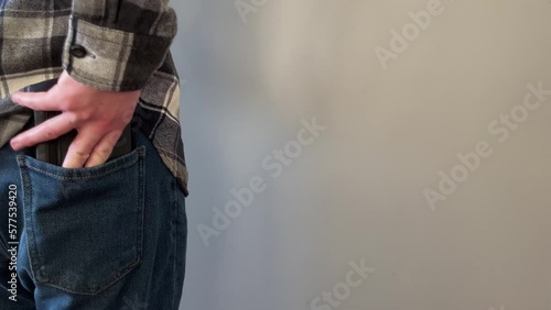 A man pulls a wallet out of the back pocket of his jeans
