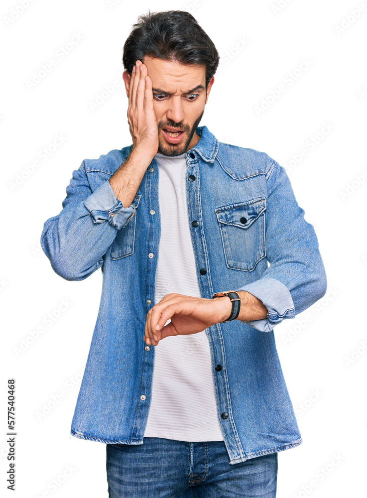 Young hispanic man wearing casual clothes looking at the watch time worried, afraid of getting late Young hispanic man wearing casual clothes looking at the watch time worried, afraid of getting late