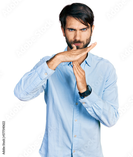 Hispanic man with blue eyes wearing business shirt doing time out gesture with hands, frustrated and serious face