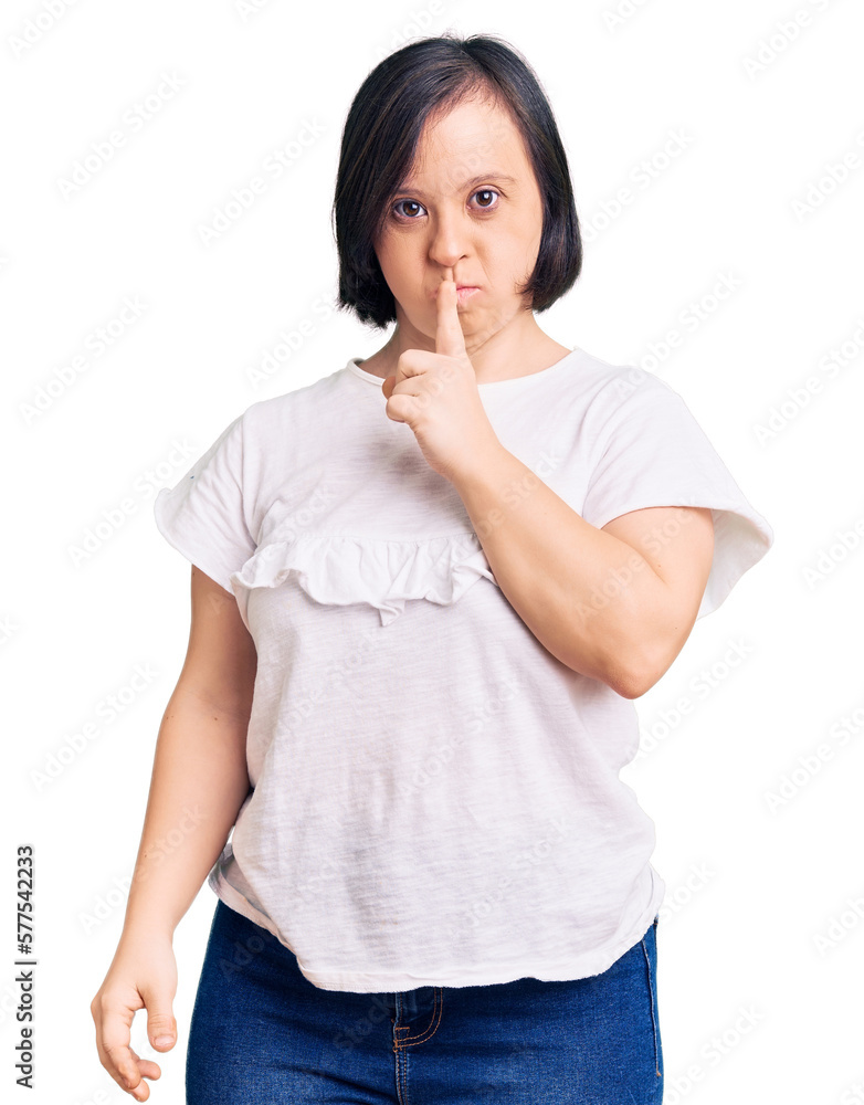 Brunette woman with down syndrome wearing casual white tshirt asking to be quiet with finger on lips. silence and secret concept. Brunette woman with down syndrome wearing casual white tshirt asking to be quiet with finger on lips. silence and secret concept.