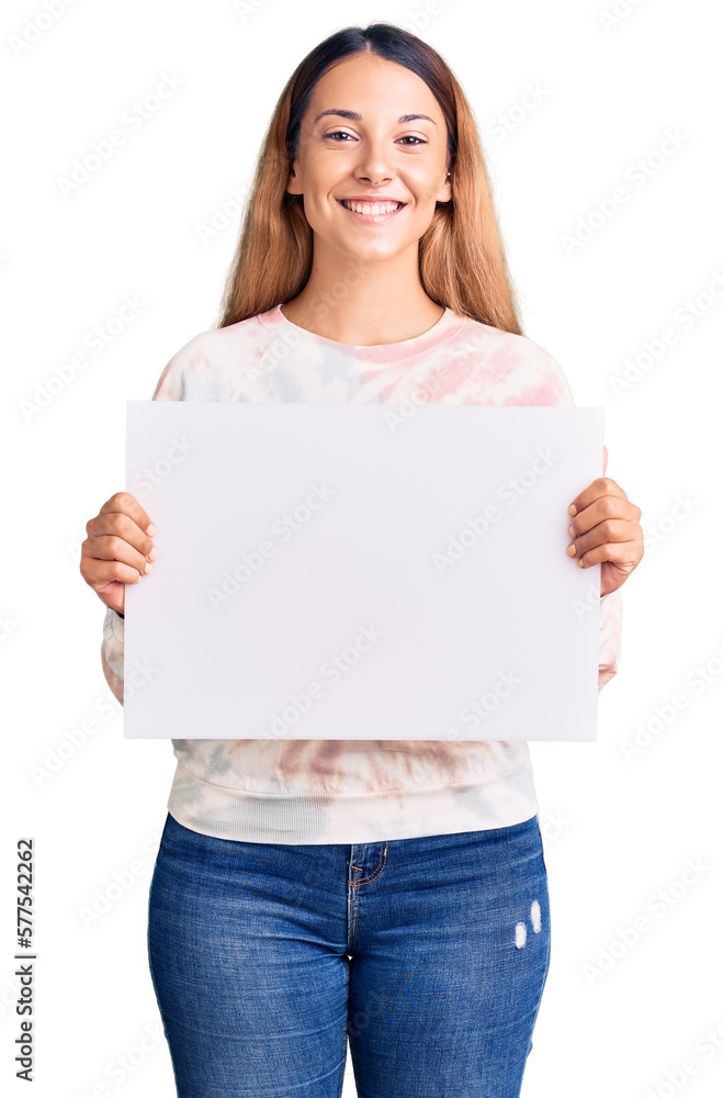 Beautiful young woman holding blank empty banner looking positive and happy standing and smiling with a confident smile showing teeth Beautiful young woman holding blank empty banner looking positive and happy standing and smiling with a confident smile showing teeth