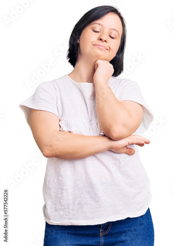 Brunette woman with down syndrome wearing casual white tshirt with hand on chin thinking about question, pensive expression. smiling and thoughtful face. doubt concept. © Krakenimages.com