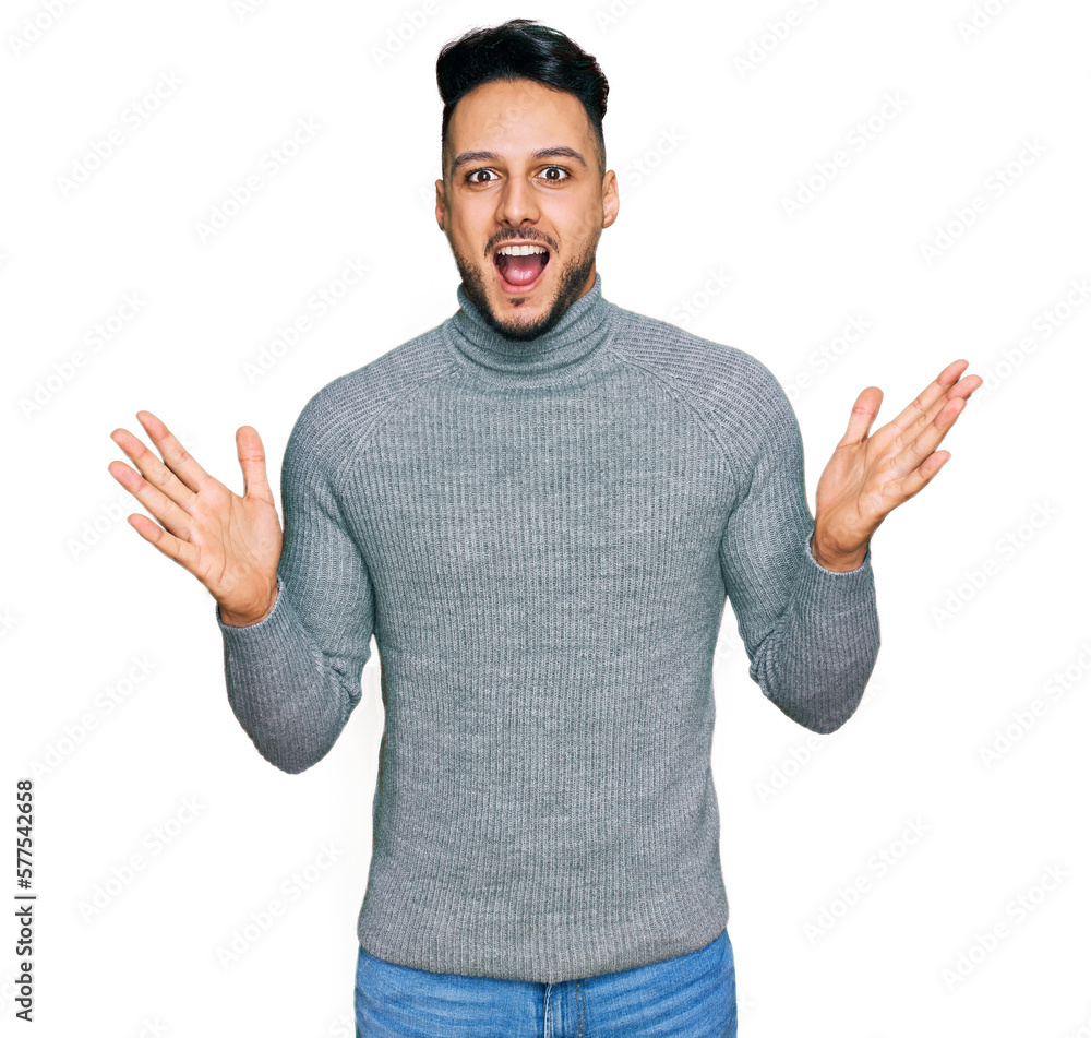 Fototapeta premium Young arab man wearing casual clothes celebrating crazy and amazed for success with arms raised and open eyes screaming excited. winner concept