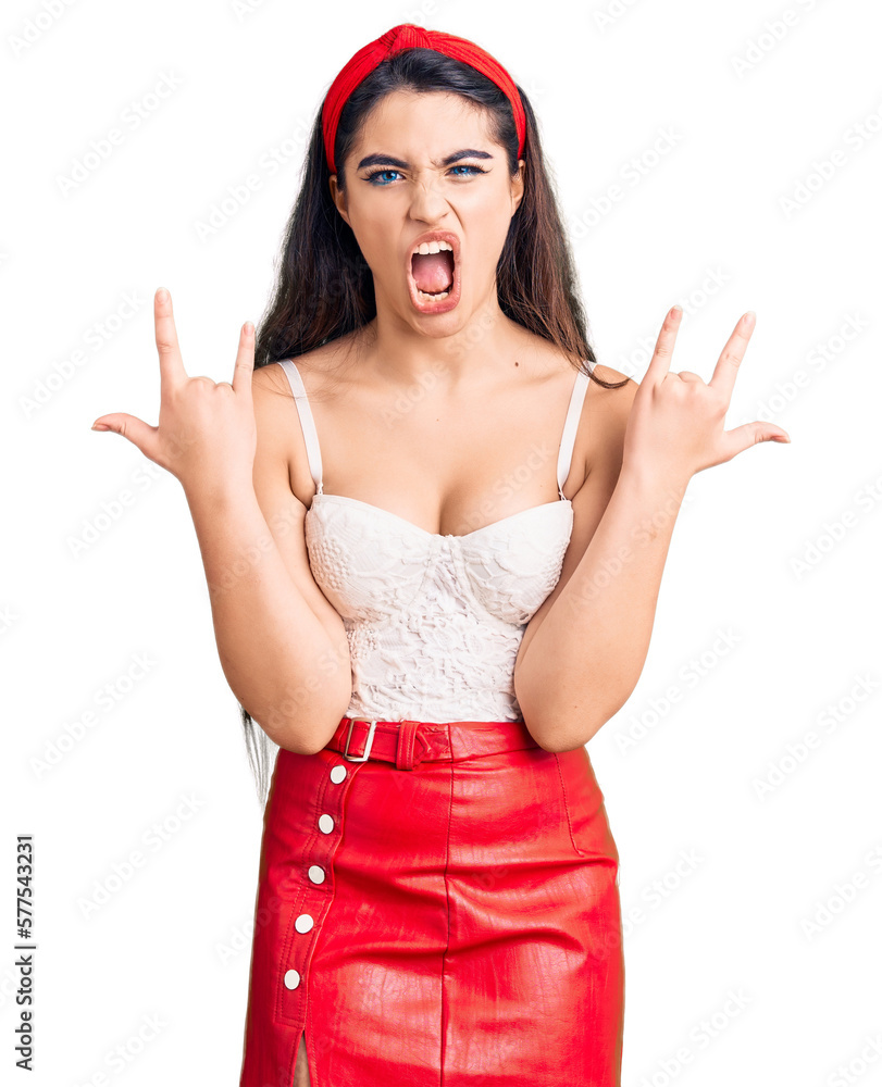 Brunette teenager girl wearing elegant look shouting with crazy expression doing rock symbol with hands up. music star. heavy concept. Brunette teenager girl wearing elegant look shouting with crazy expression doing rock symbol with hands up. music star. heavy concept.