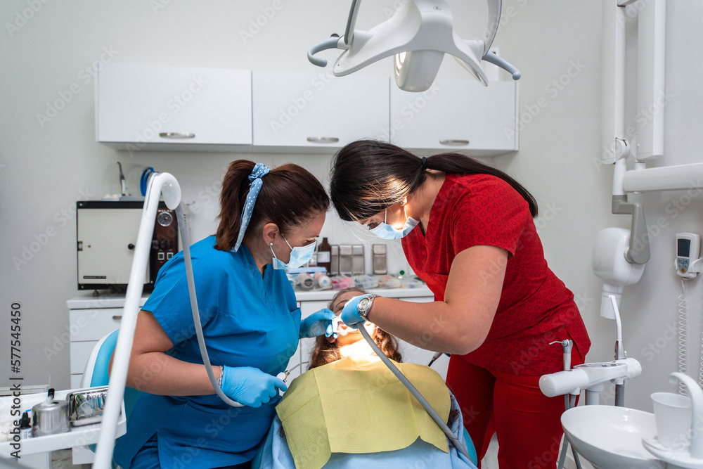 Dentist appointment at a dental clinic, placing braces locks on the teeth and pulling the archwire to fix it Dentist appointment at a dental clinic, placing braces locks on the teeth and pulling the archwire to fix it