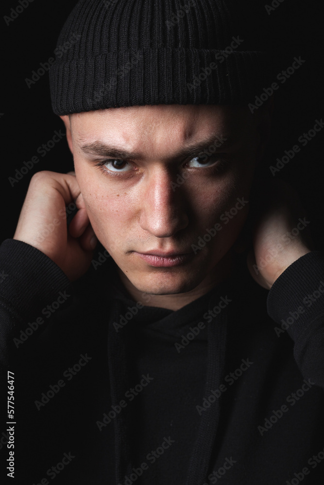 Studio portrait of handsome hipster guy wearing black blank hoodie or sweatshirt and hat. Mockup for print. Studio portrait of handsome hipster guy wearing black blank hoodie or sweatshirt and hat. Mockup for print.
