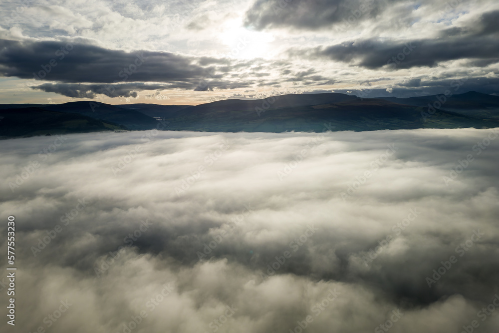 Aerial view of sunset over a bank of fog with distant mountains