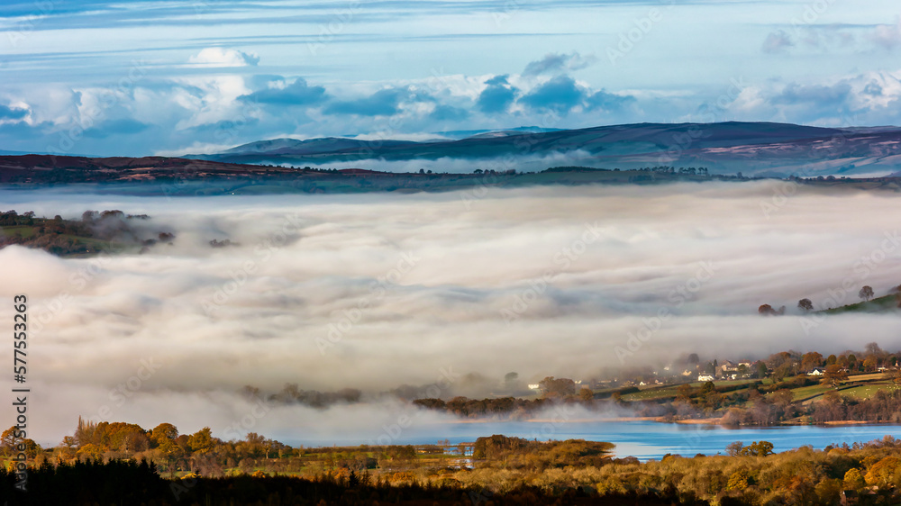 Low lying fog and cloud in a rural valley surrounded by farmland and fields (Brecon Beacons, Wales)