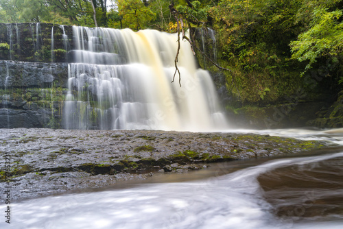 Spectacular waterfall surrounded by trees at Waterfall Country  Brecon Beacons  Wales